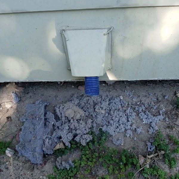 Exterior dryer vent after cleaning — massive lint buildup removed from the outside vent cap